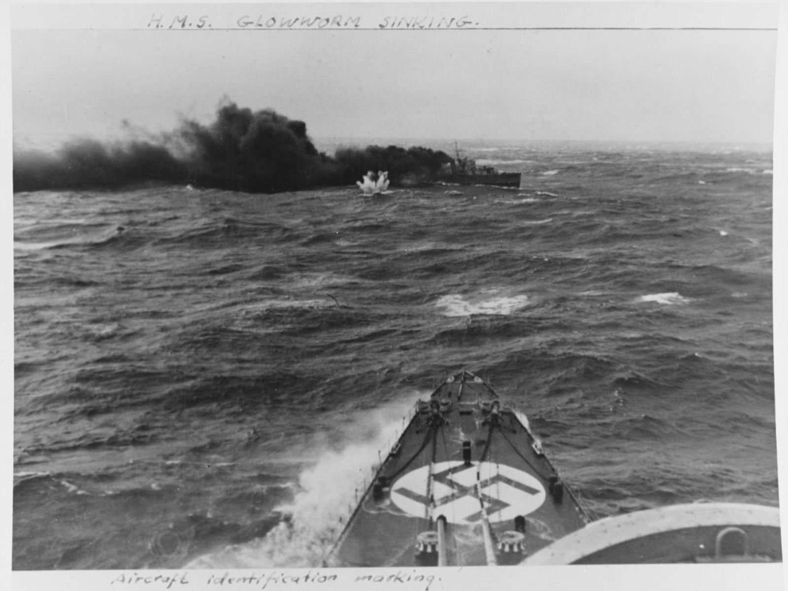 Fotografia autêntica tirada da proa do Admiral Hipper durante o combate. Mostra o HMS Glowworm ao longe, envolvido em fumaça negra e chamas. No topo da foto está escrito "H.M.S. GLOWWORM SINKING" e na parte inferior "AIRCRAFT IDENTIFICATION MARKING". Esta é uma das raras fotografias reais da batalha.