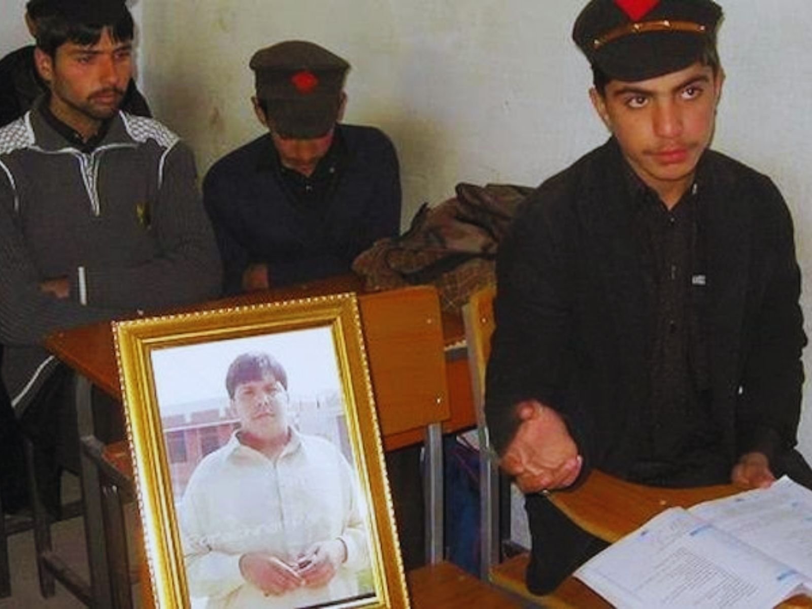 A foto do estudante Aitzaz Hasan é colocada junto aos seus colegas na escola que ele ajudou a salvar no Paquistão.