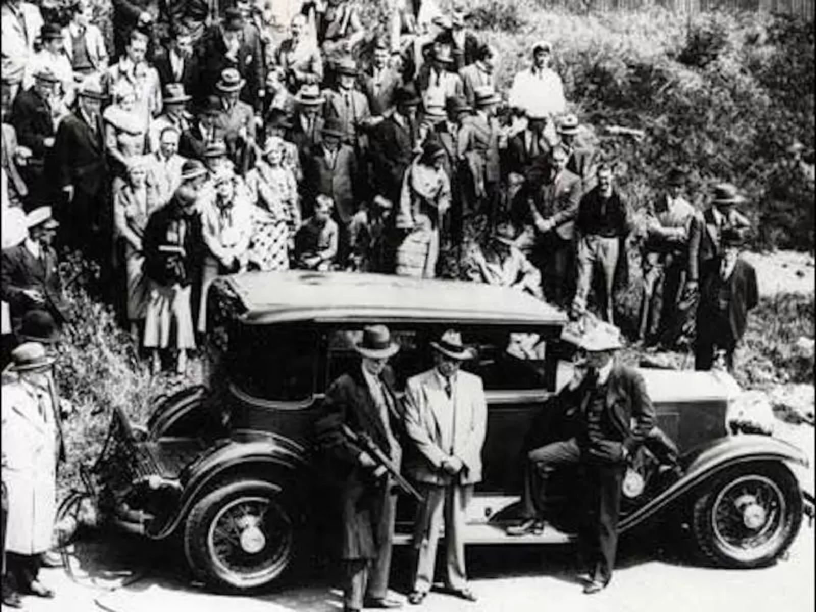 Mafiosos ao lado de um dos carros da Chicago Outfit. O carro favorito de Al Capone era um Cadillac Sedan 1928 V8 customizado e blindado, um símbolo de sua riqueza e poder.