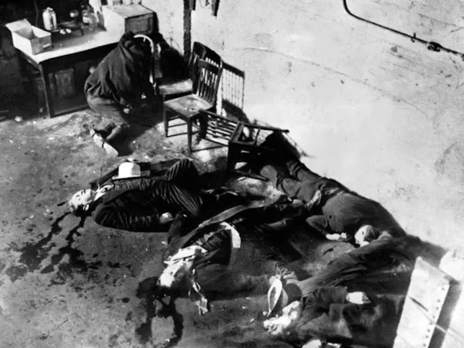 Cadáveres espalhados no chão no dia do Massacre do Dia de São Valentim. Em 1929, atiradores de Al Capone, disfarçados de policiais, metralharam 7 rivais inimigos à queima-roupa, um dos eventos mais brutais da era da Lei Seca.