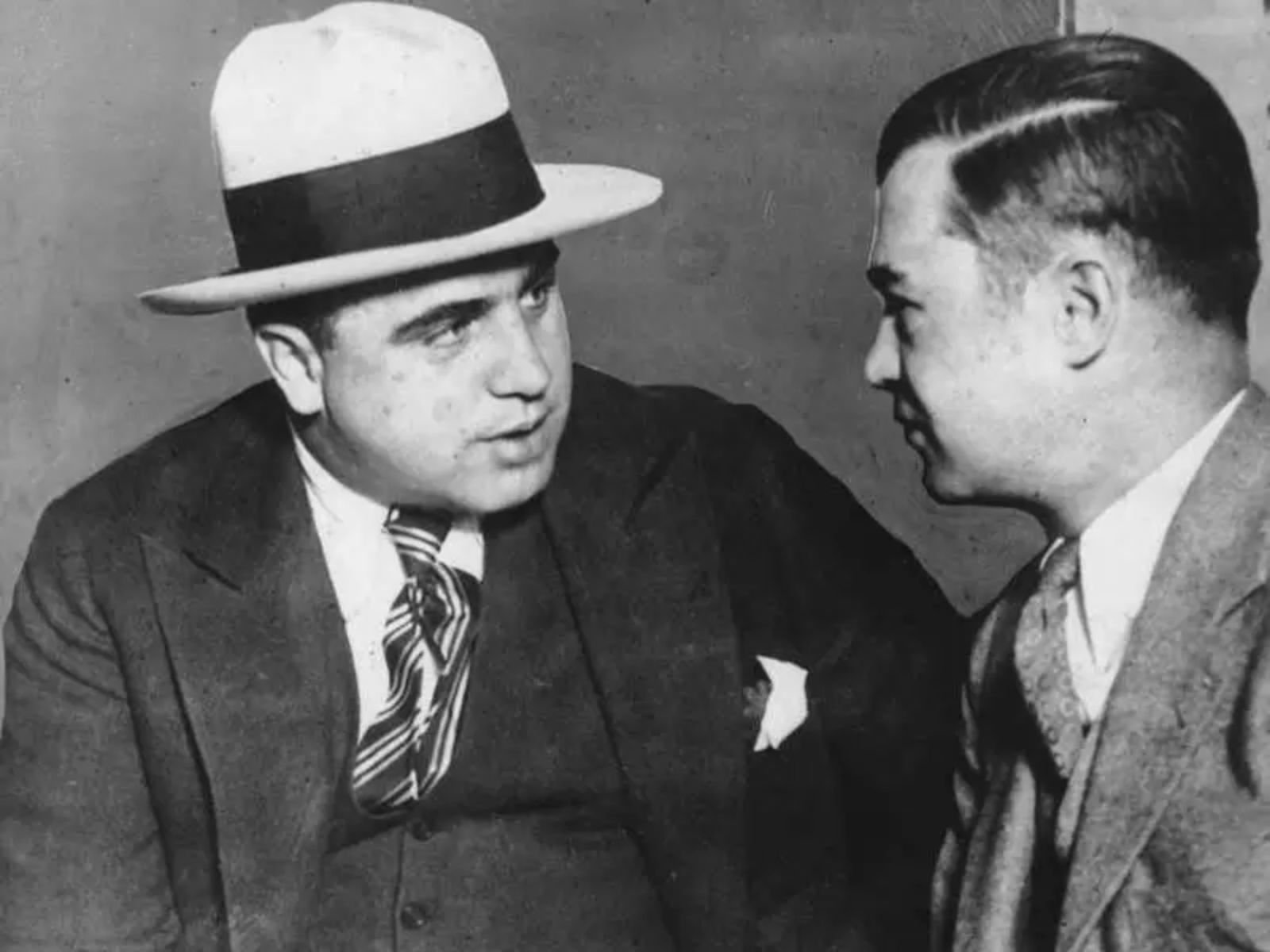 Al Capone conversa com um homem antes de comparecer ao júri em março de 1929. Ele foi intimado pelo Bureau of Investigation e posteriormente preso por desacato ao tribunal.