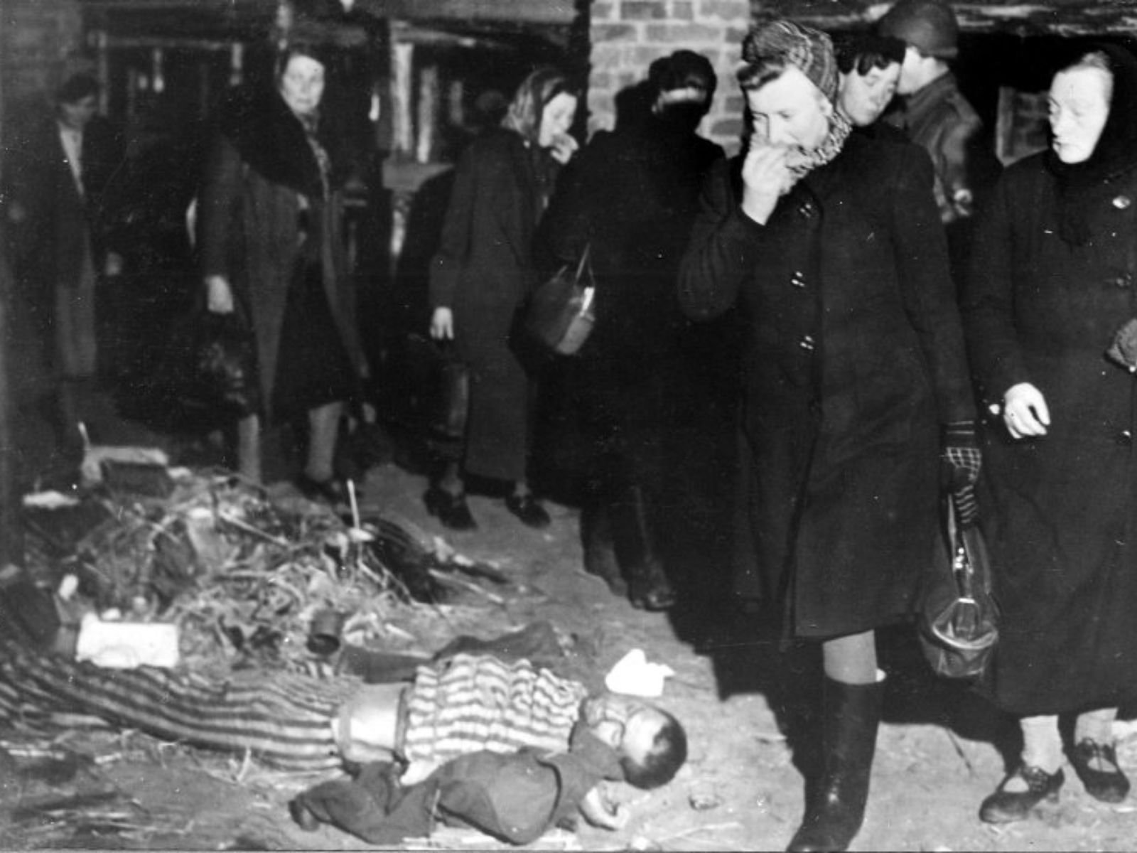 Cidadãos alemães da cidade de Weimar são forçados por soldados americanos a caminhar pelos corpos de prisioneiros mortos no campo de concentração de Buchenwald, em abril de 1945. A medida fazia parte da política de desnazificação para confrontar a população com as atrocidades cometidas pelo regime nazista. Autor: U.S. Army Signal Corps / National Archives.