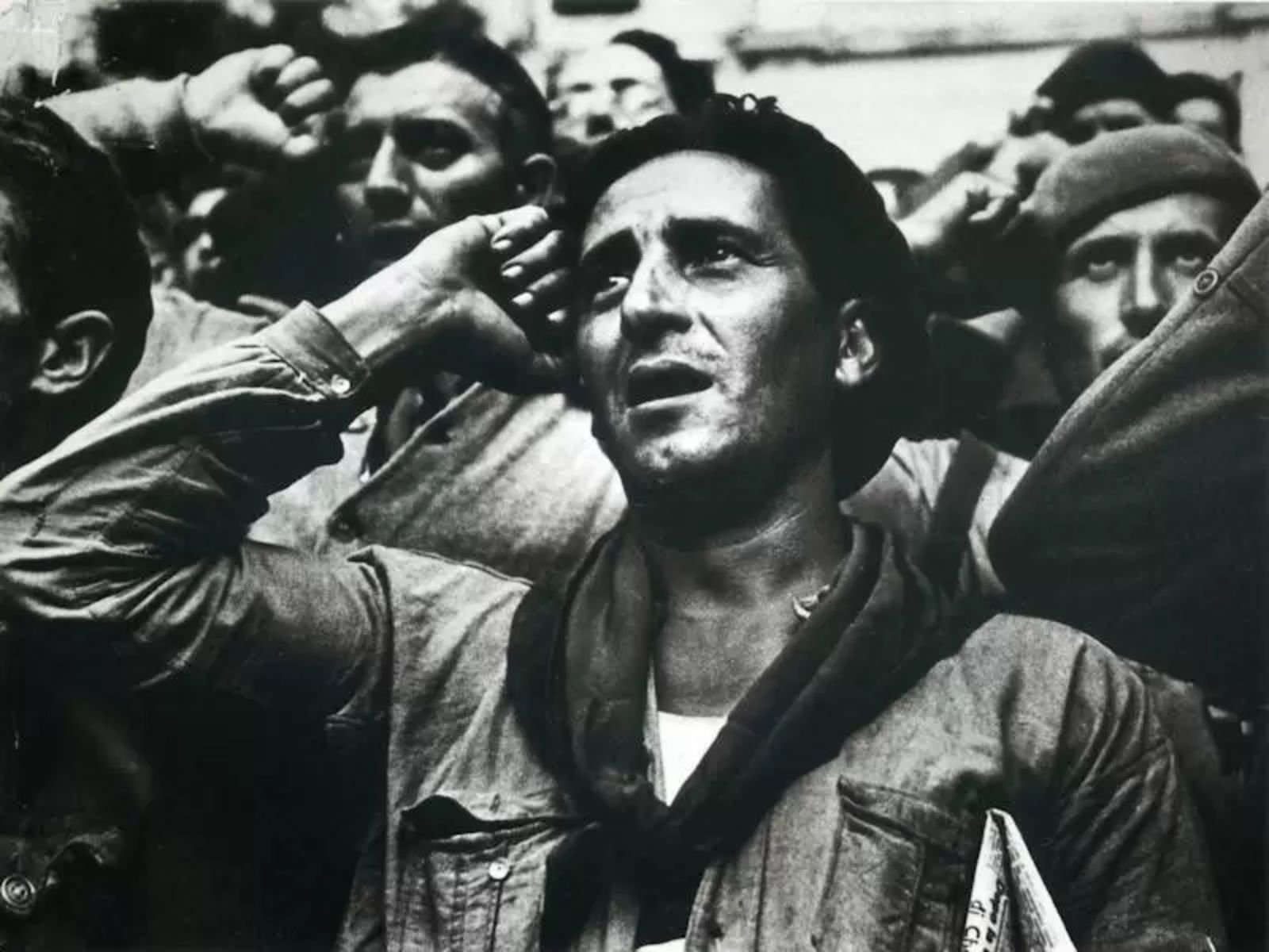 "Salud, hermanos!" ("Saúde, irmãos!"). Durante um discurso em Montblanch, na Catalunha, em outubro de 1938, o primeiro-ministro Juan Negrín agradeceu aos combatentes das Brigadas Internacionais pelos serviços prestados à causa republicana durante a Guerra Civil Espanhola (1936-1939). Naquele momento do conflito, os nacionalistas já controlavam grande parte do território espanhol e muitos republicanos fugiram em busca de refúgio para a França e outros países. Foto de Robert Capa.