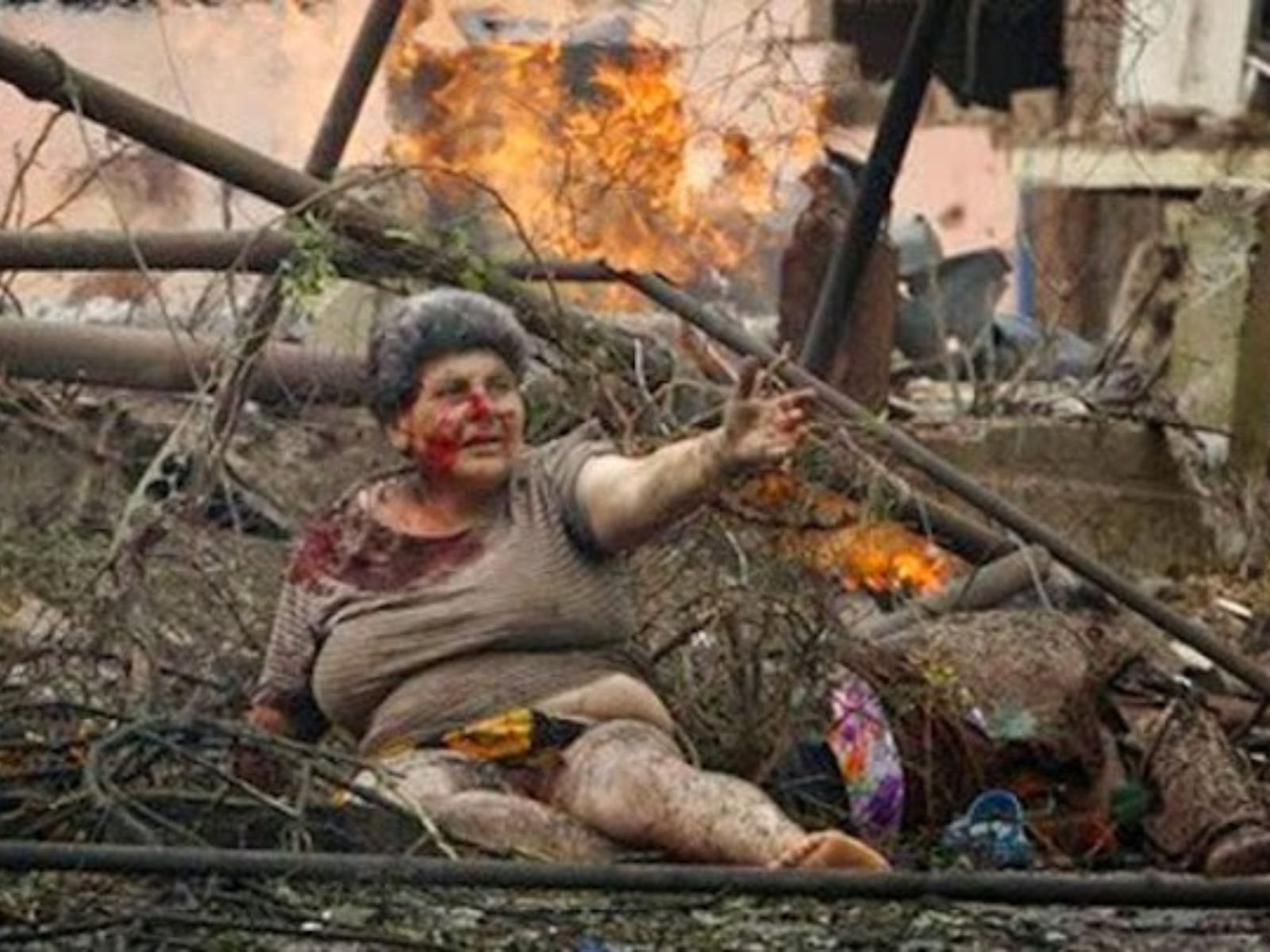 Mulher ferida chora em frente a um edifício de apartamentos, bombardeado durante um ataque aéreo russo. O incidente ocorreu no norte da cidade georgiana de Gori, no dia 9 de agosto de 2008. De acordo com o fotógrafo, a mulher ferida foi auxiliada por vizinhos e evacuada para uma área segura. (AP Photo/George Abdaladze)