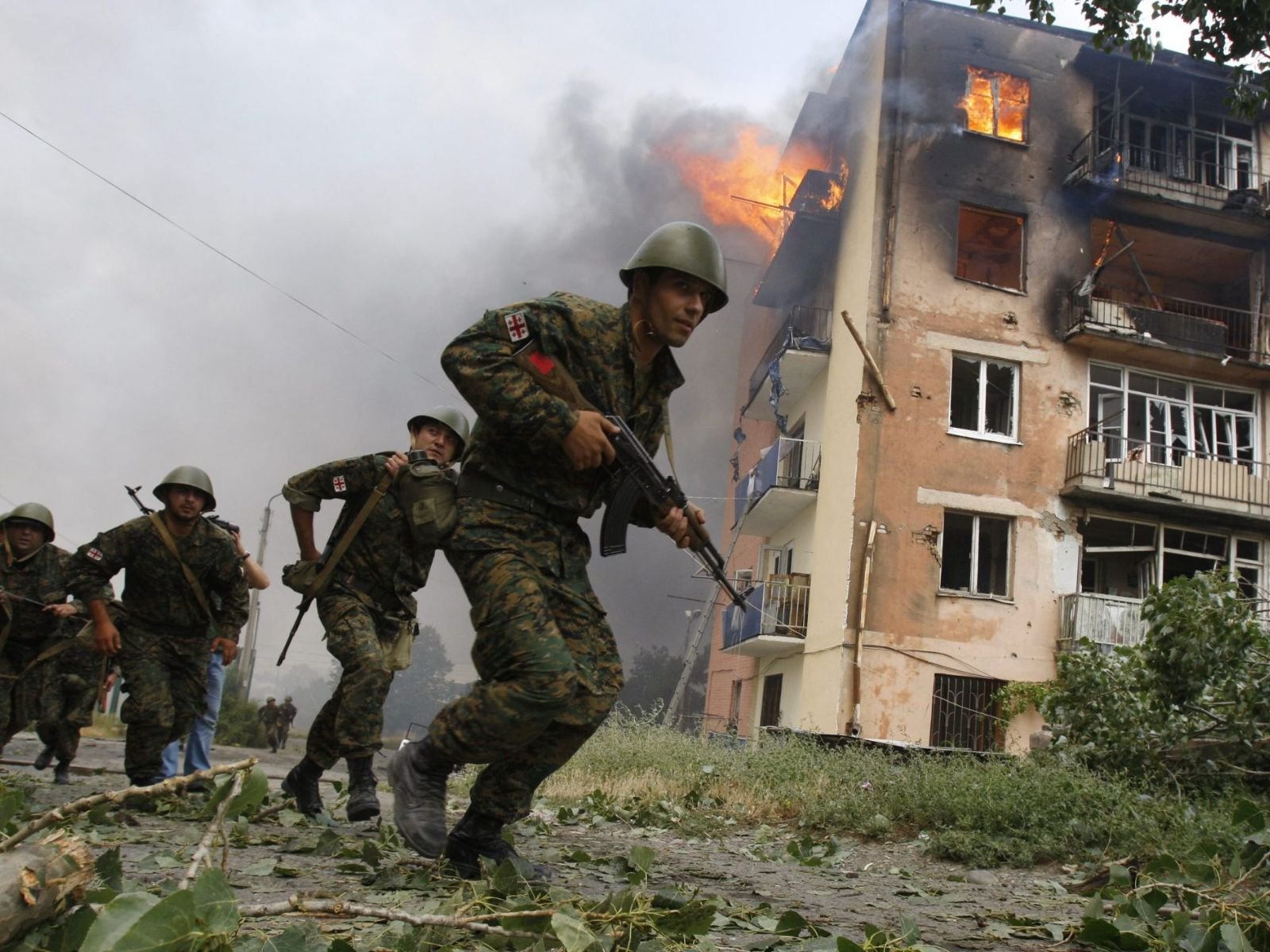 Soldados georgianos correm para se abrigar durante um combate intenso em Tskhinvali, a capital da Ossétia do Sul, no início do conflito. A resposta georgiana foi uma reação a meses de provocações e ataques separatistas apoiados pela Rússia.