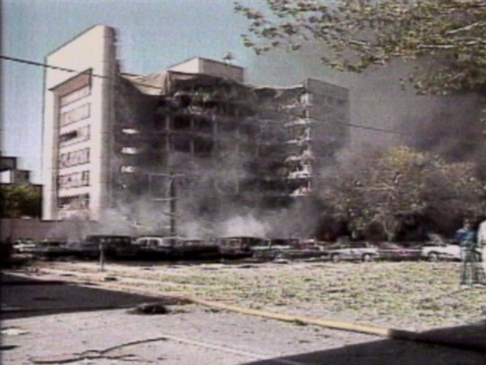 Imagem capturada no momento da explosão do Edifício Murrah em Oklahoma City, às 9:02 da manhã de 19 de abril de 1995. A nuvem de fumaça e detritos se eleva sobre a cidade, marcando o momento exato em que Timothy McVeigh executou o pior atentado terrorista doméstico da história americana, matando 168 pessoas, incluindo 19 crianças. Fonte: ABC News.