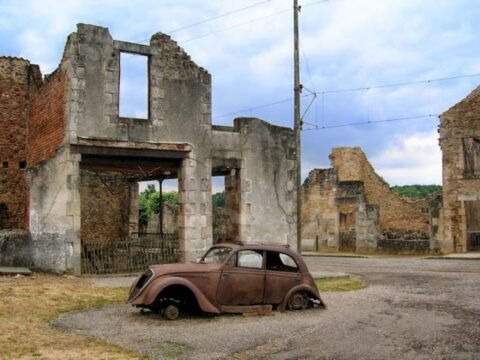 Oradour-sur-Glane: O Massacre Congelado no Tempo A carcaça de um Peugeot 202, pertencente ao médico da aldeia, Dr. Desourteaux, permanece como uma sentinela silenciosa nas ruínas de Oradour-sur-Glane.