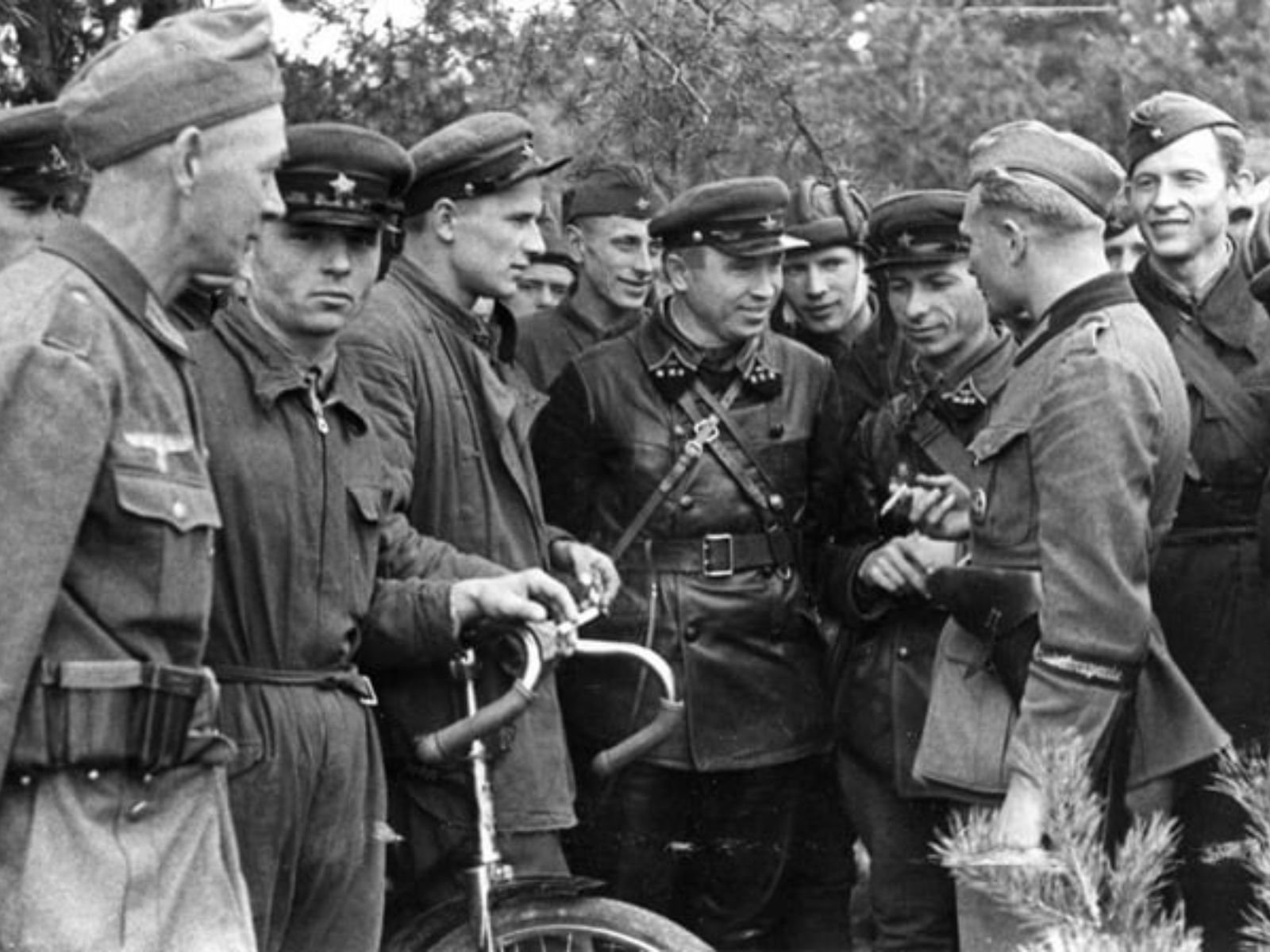 Fotografia histórica mostrando oficiais soviéticos (à esquerda) e alemães (à direita) confraternizando após a conquista conjunta da cidade polonesa de Brest-Litovsk. Os oficiais aparecem conversando de forma amigável, com um oficial alemão ao centro. Brest-Litovsk foi inicialmente capturada pelos alemães em 14 de setembro de 1939. Em 22 de setembro, a cidade foi transferida para o controle soviético conforme acordado no Pacto Ribbentrop-Molotov.