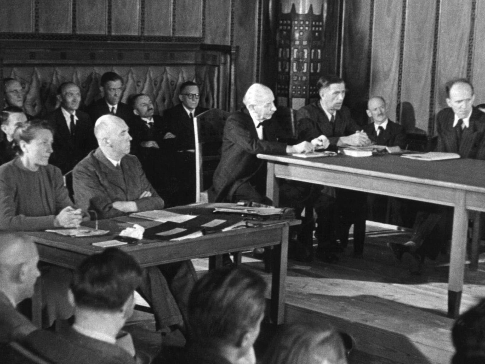 Um tribunal de desnazificação (Spruchkammer) em sessão. Esses tribunais, muitas vezes compostos por alemães, eram responsáveis por julgar milhões de casos. Winifred Wagner (à esquerda) ao lado de seu advogado de defesa, Fritz Meyer, durante a leitura das acusações perante o segundo tribunal de desnazificação em Bayreuth, em 25 de junho de 1947. A nora de Richard Wagner também aparece na seleção de Niklas Frank. Fonte: Picture-Alliance / DPA /Deutschlandfunk.